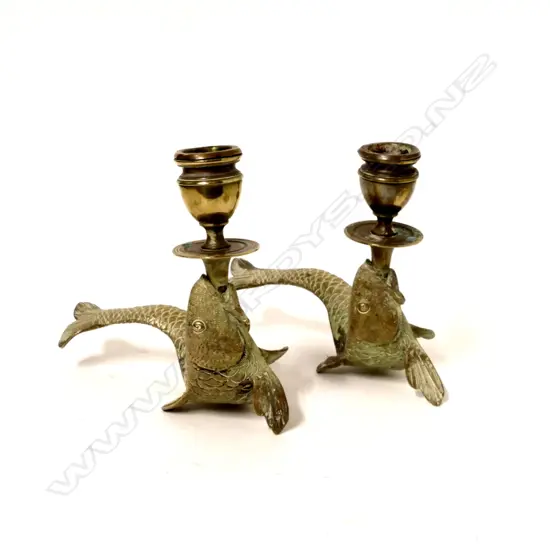A pair of old brass fish based candlesticks
