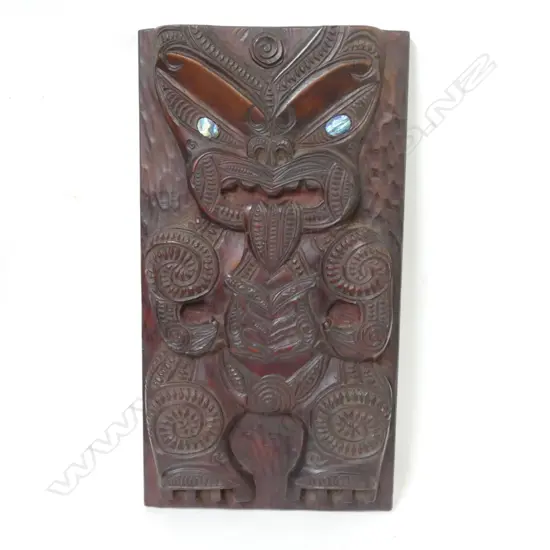 A carved wood Maori panel
