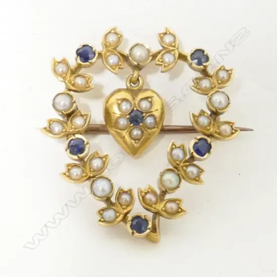 An Edwardian 15ct. yellow gold sapphire and seed pearl open heart brooch