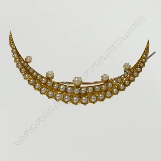 An Edwardian 15ct. yellow gold and seed pearl crescent-form brooch