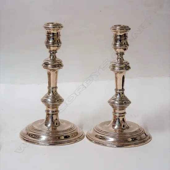 A pair of cast Georgian style silver column candlesticks