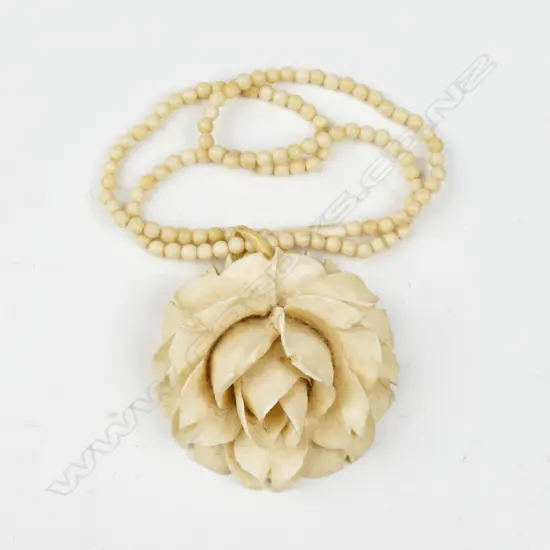 A large vintage carved ivory flower head pendant on an ivory bead necklace