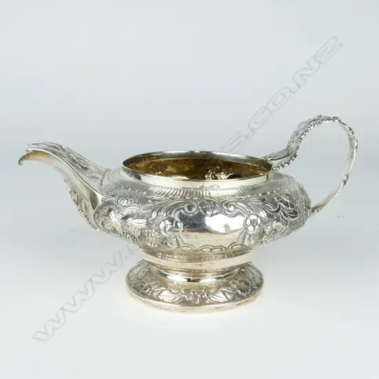 A George IV embossed circular cream jug