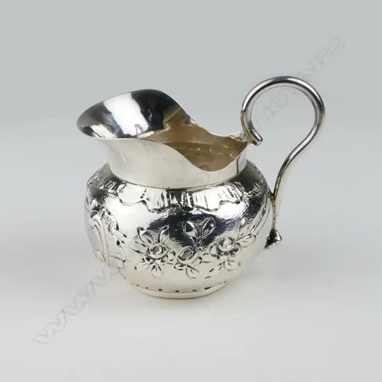 A small silver wide mouth cream jug