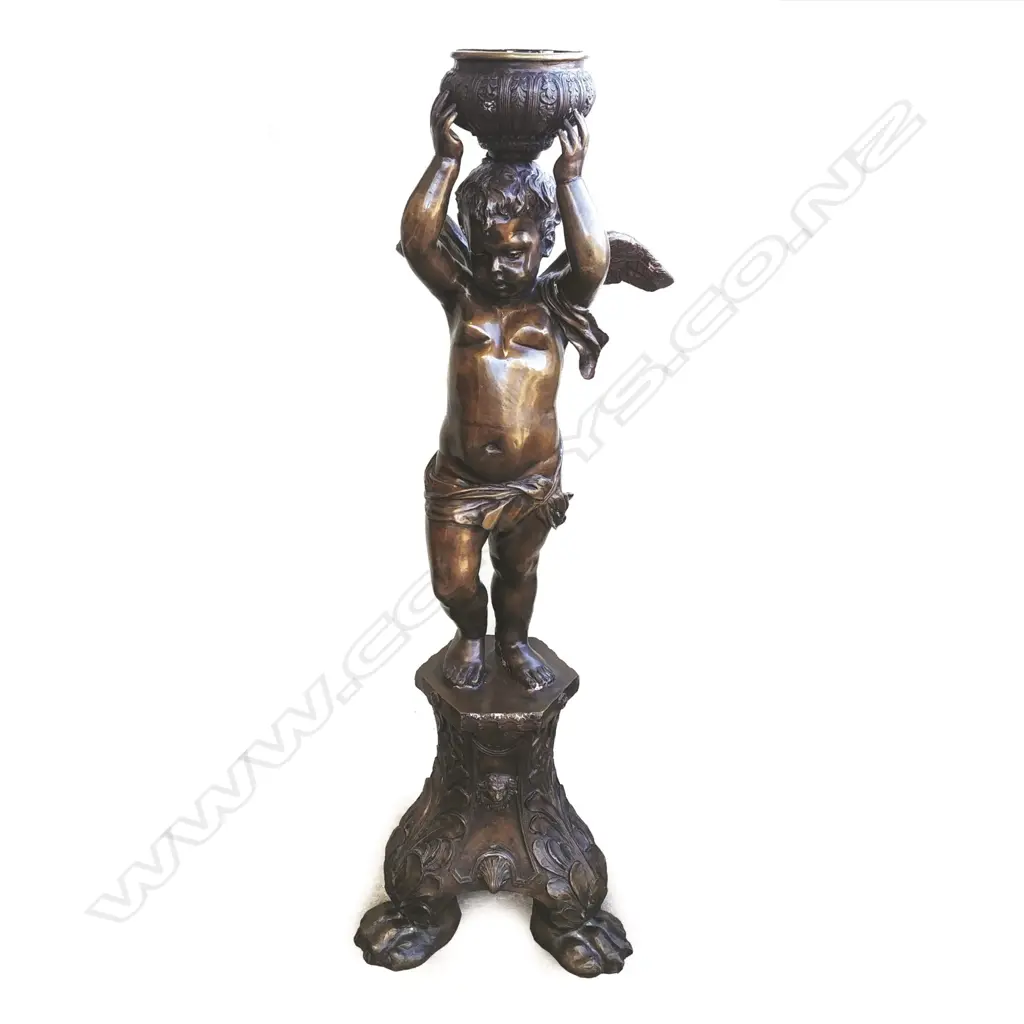A tall bronze figure of a standing cupid holding bowl aloft Image 1++