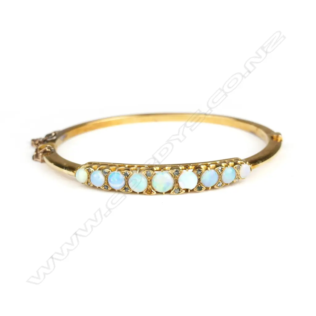 An early 20thC 15ct. yellow gold opal and diamond set hinged bangle Image 1++