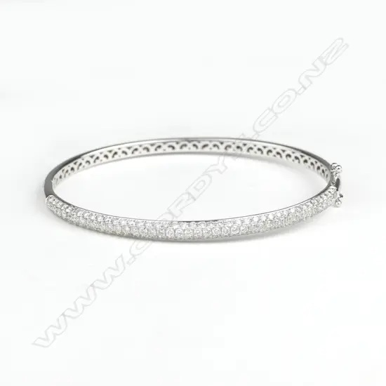 A lady's modern 18ct. white gold and diamond set traditional style bangle