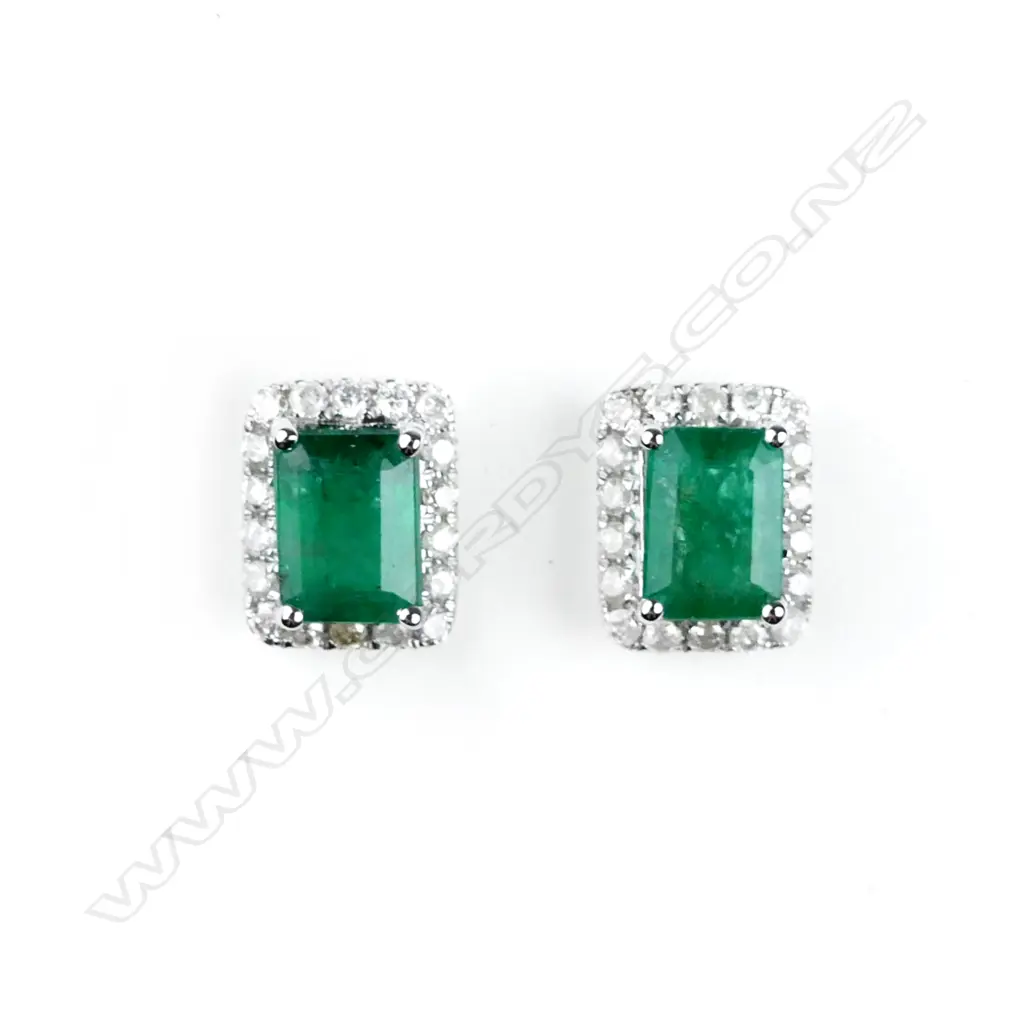 A pair of 14ct. white gold emerald and diamond stud earrings Image 1++