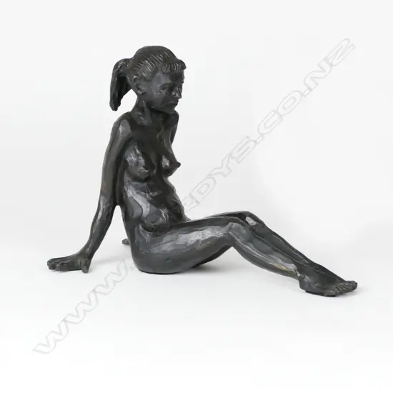 A bronze figure of a reclining young naked woman