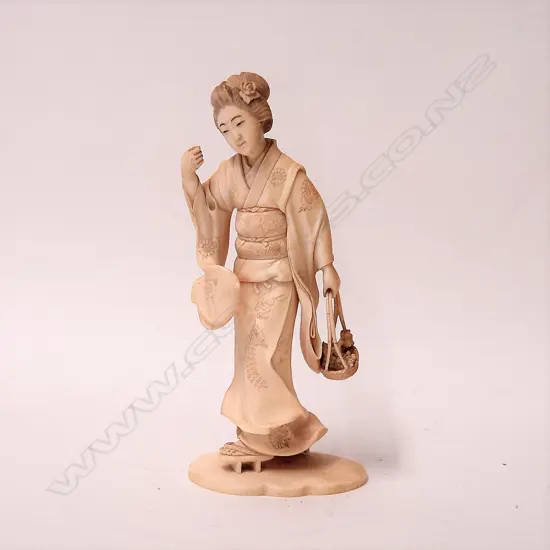 A Japanese Meiji carved ivory okimono of a geisha