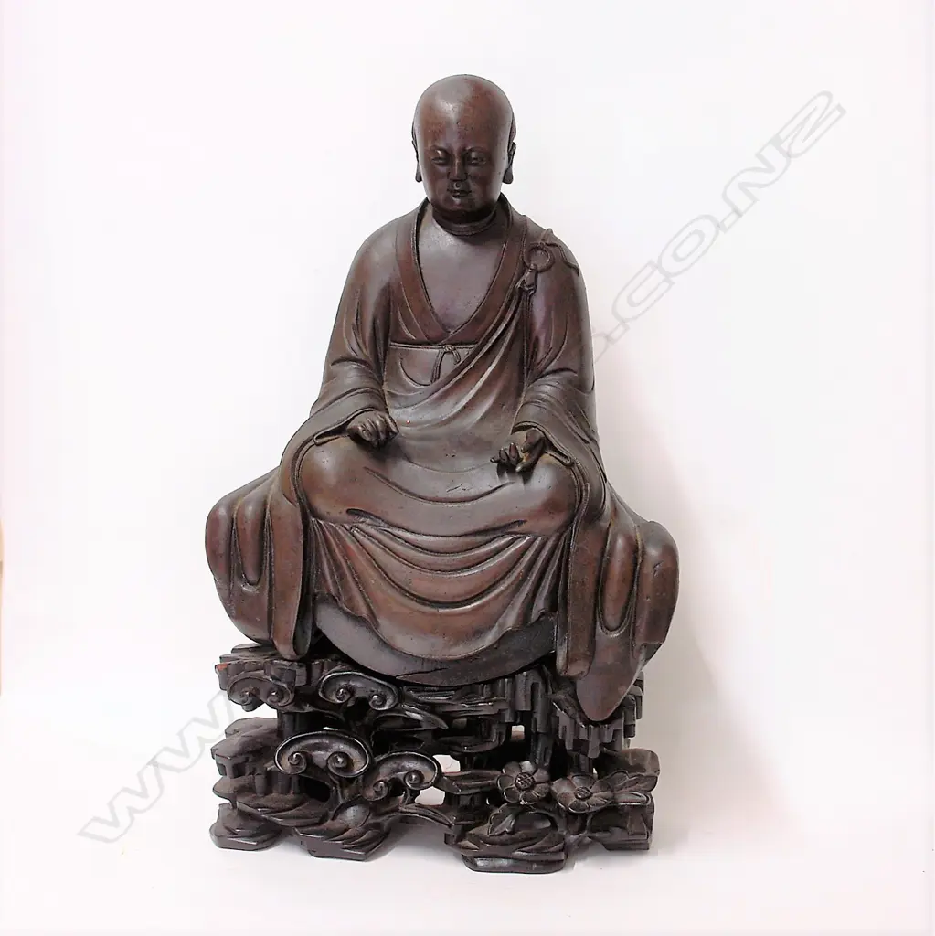 An 19thC or earlier Chinese bronze seated monk on carved wooden stand Image 1++