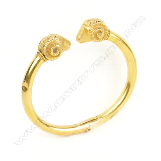 A late 19thC 14ct. yellow gold double ram's head hinged bangle