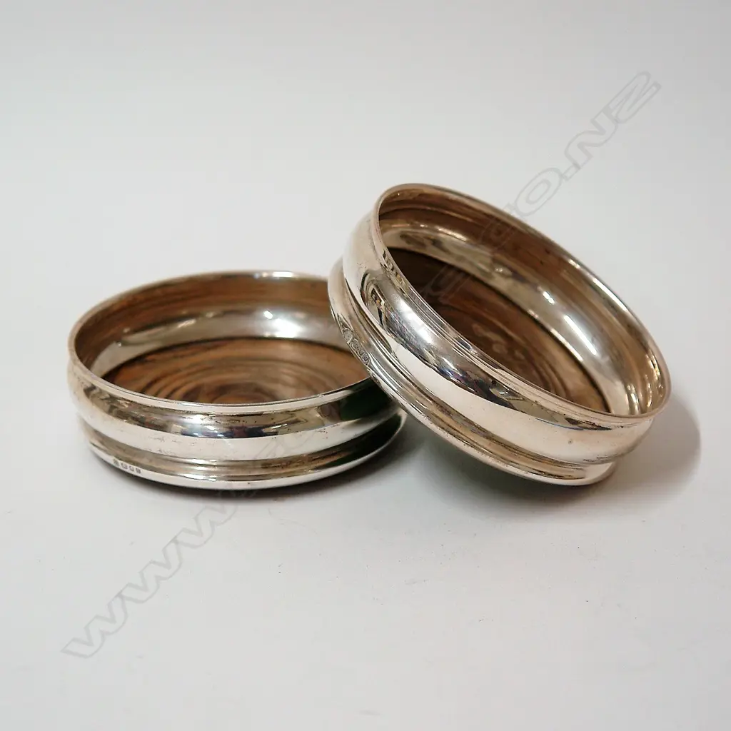 A pair of silver and turned wood bottle coasters Image 1++