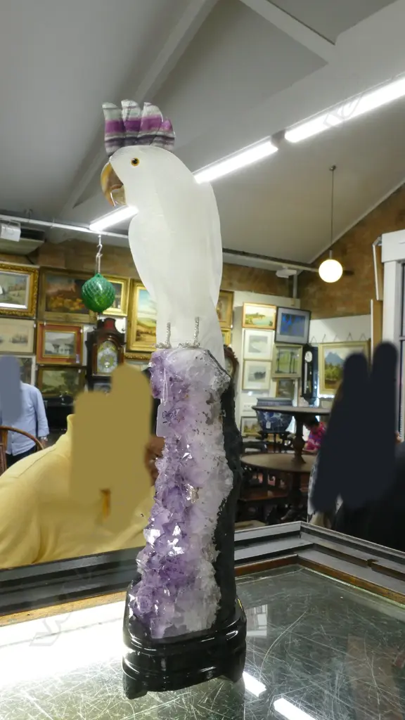 A sculpted alabaster parrot on amethyst geode base Image 1++