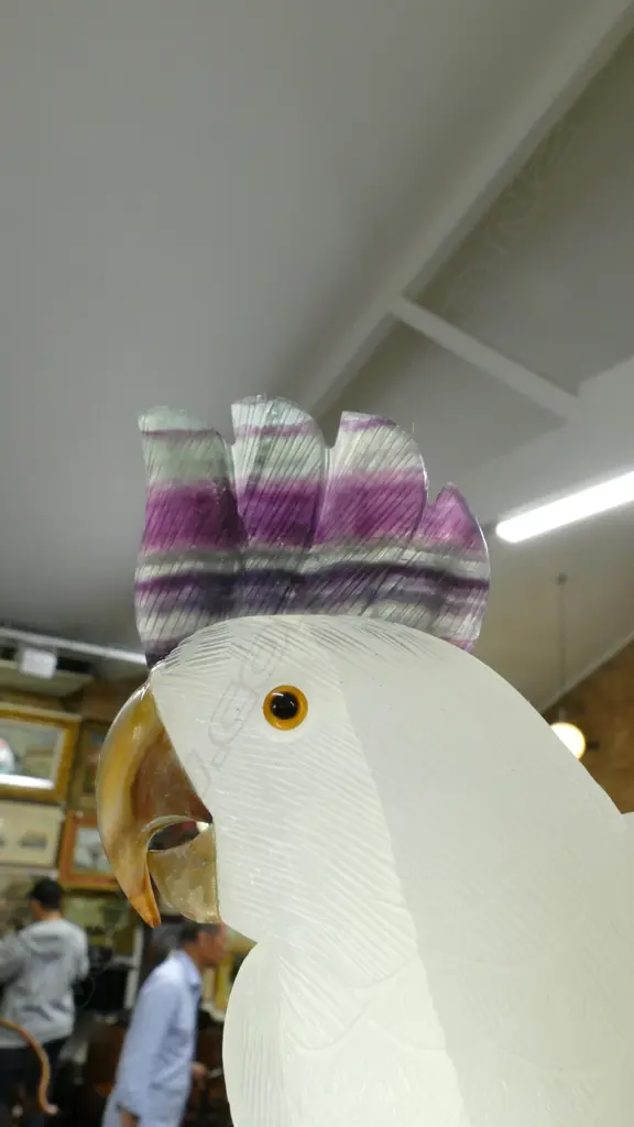 A sculpted alabaster parrot on amethyst geode base Image 1++