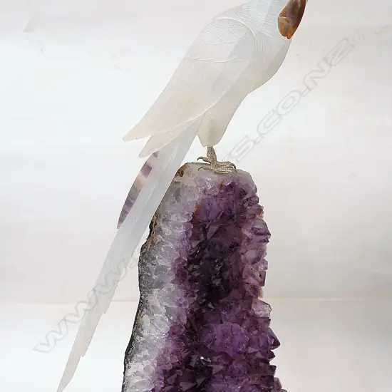 A sculpted alabaster parrot on amethyst geode base