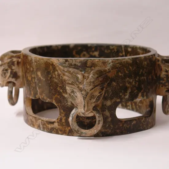 A Chinese green stone carved open cylinder