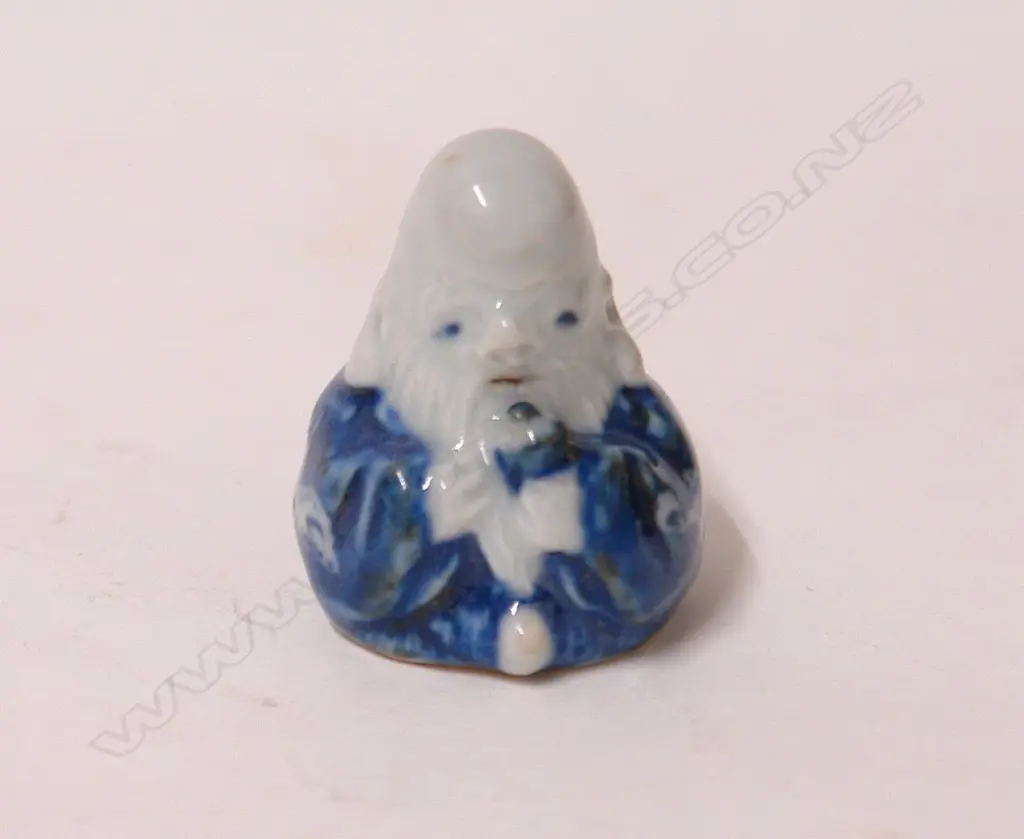 A small porcelain seated Hotei type netsuke Image 1++