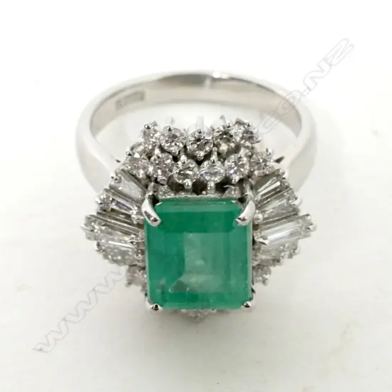A platinum emerald and diamond ring