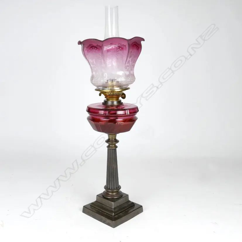 A Victorian cast iron and cranberry kerosene lamp Image 1++