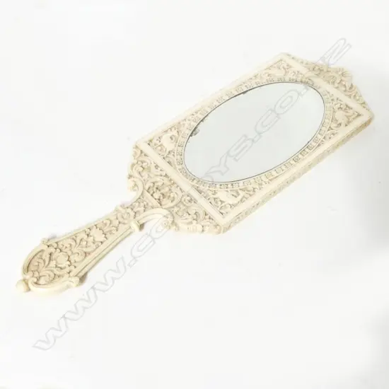 A carved Indian ivory hand mirror
