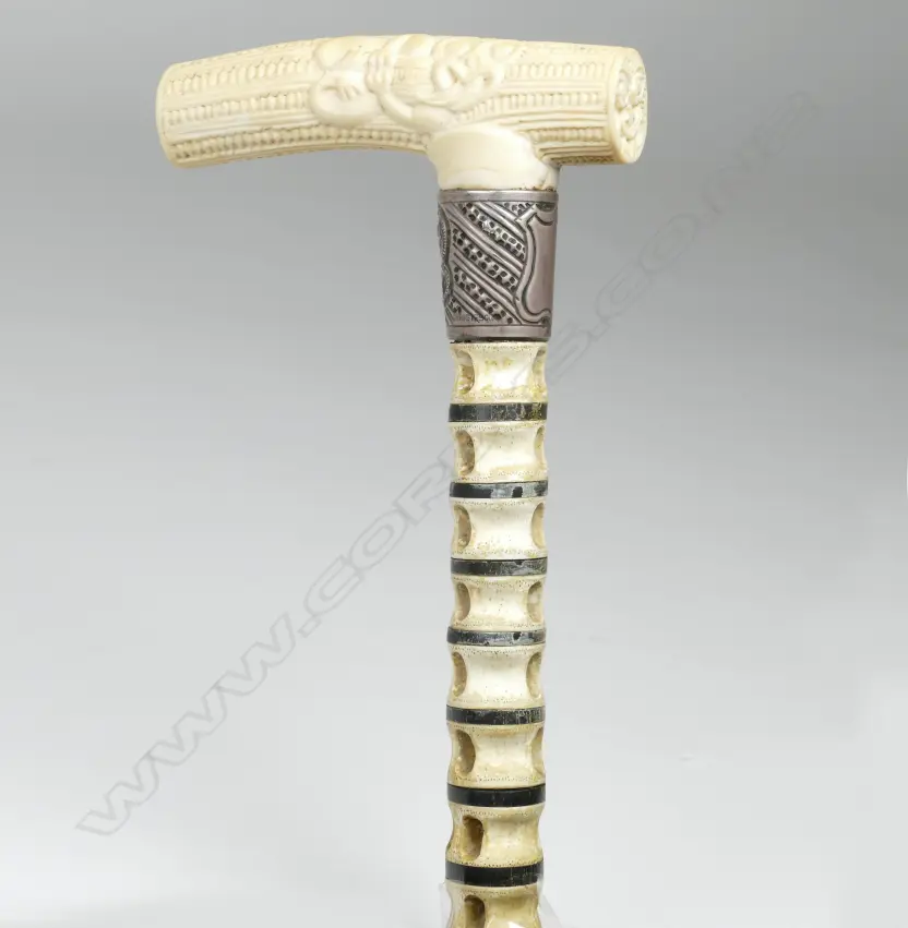 A walking stick made of shark vertebrae with an ivory handle carved with Maori designs. The 65 graduated vertebrae interspersed by horn discs Image 1++