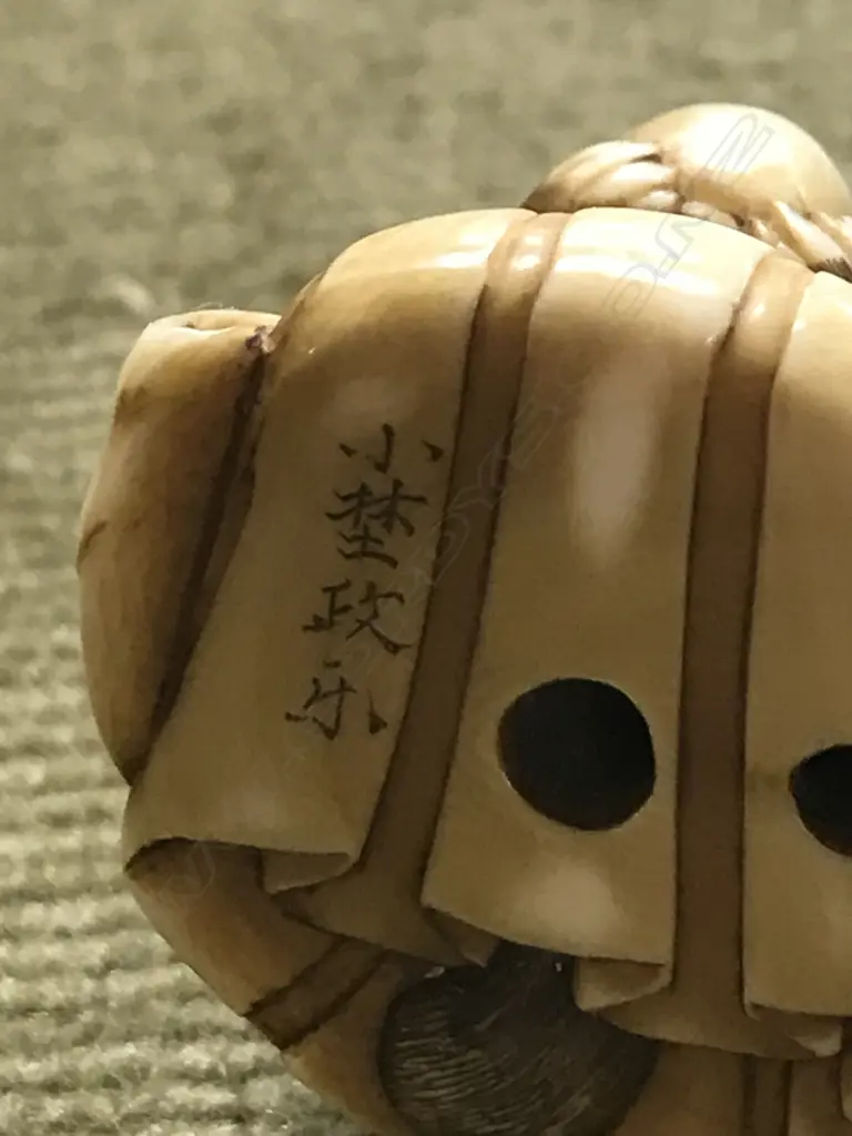 An early 20thC finely carved ivory netsuke of Tanuki seated with child Image 1++