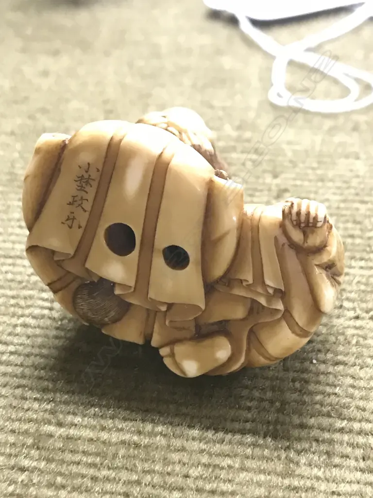 An early 20thC finely carved ivory netsuke of Tanuki seated with child Image 1++