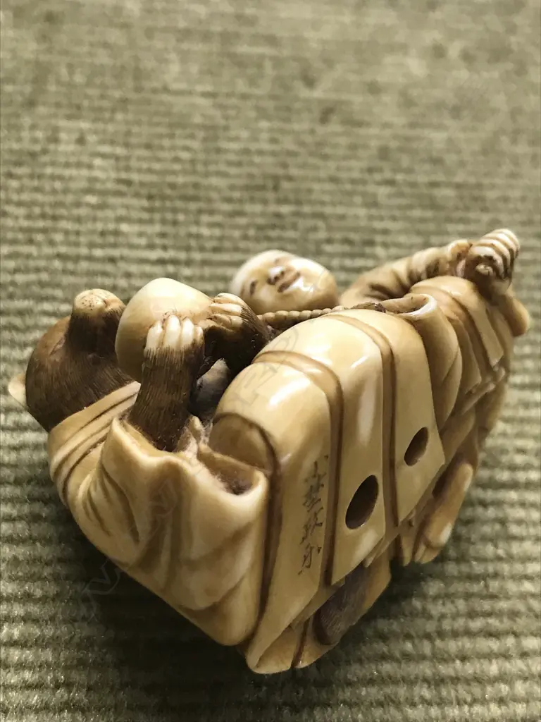 An early 20thC finely carved ivory netsuke of Tanuki seated with child Image 1++