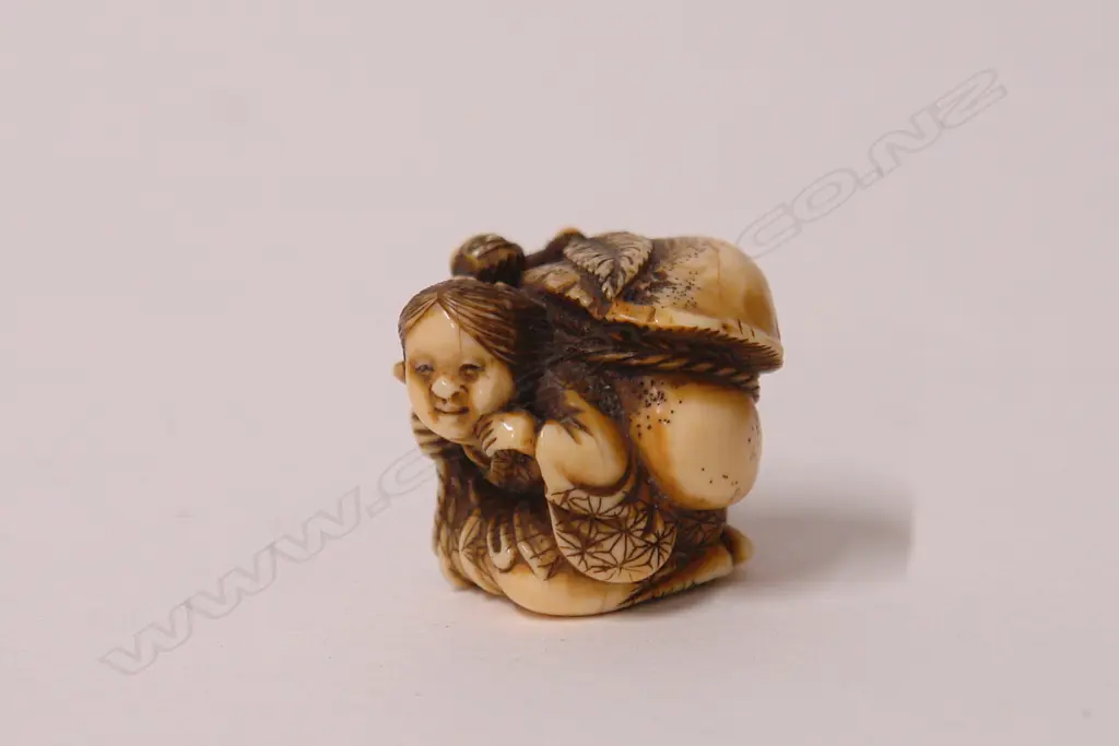 A fine old Japanese carved ivory netsuke of Okame Image 1++