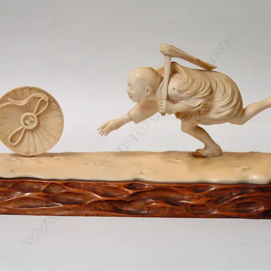 An old Japanese characterful carved ivory figure on stand