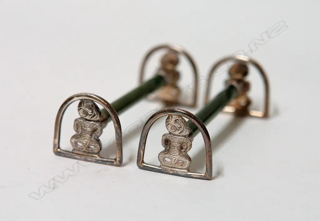 A pair of early 20thC N.Z. themed tiki silver and greenstone knife rests Image 1++