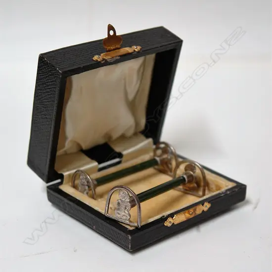 A pair of early 20thC N.Z. themed tiki silver and greenstone knife rests