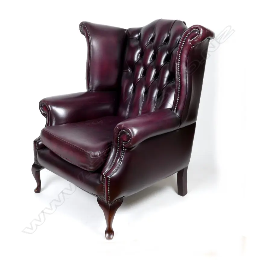A large deep burgundy leather wing back armchair Image 1++