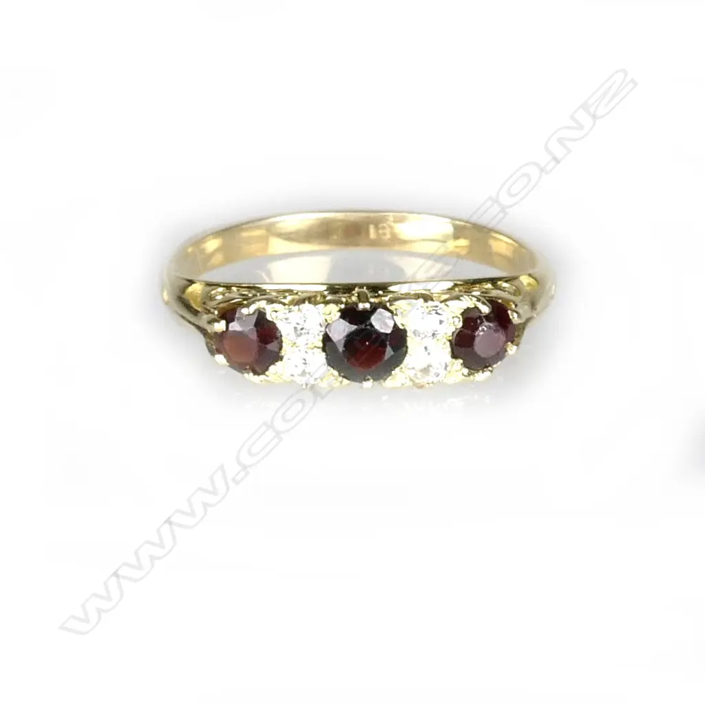 An 18ct. yellow gold garnet and diamond bridge ring Image 1++