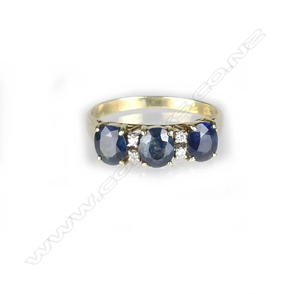 An 18ct. yellow gold three stone sapphire ring Image 1++