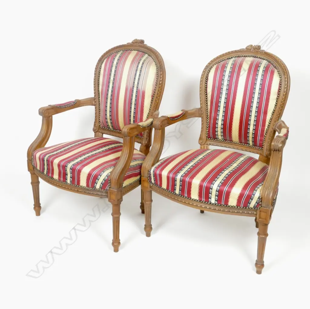 A pair of French Louis XVI style walnut open elbow chairs with cartouche backs Image 1++