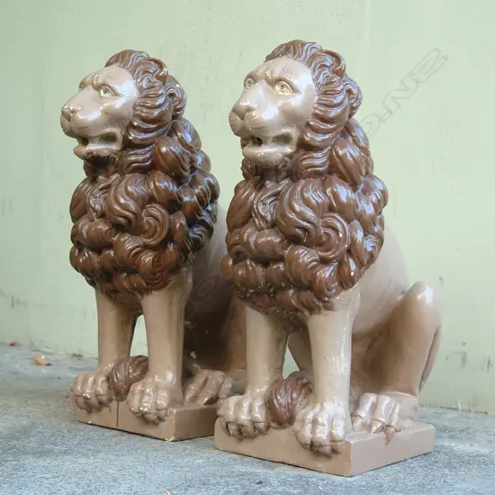 A pair of early/mid 20thC cast composite classical seated lions
