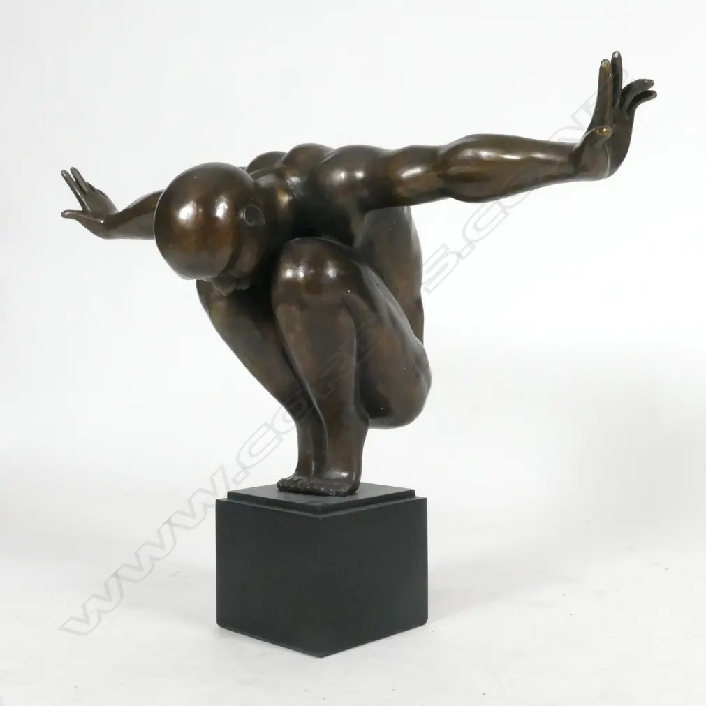 A bronze statue of a man in balanced toe stand pose Image 1++