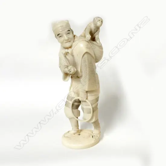 A Japanese carved ivory figure of a performer and tame monkey