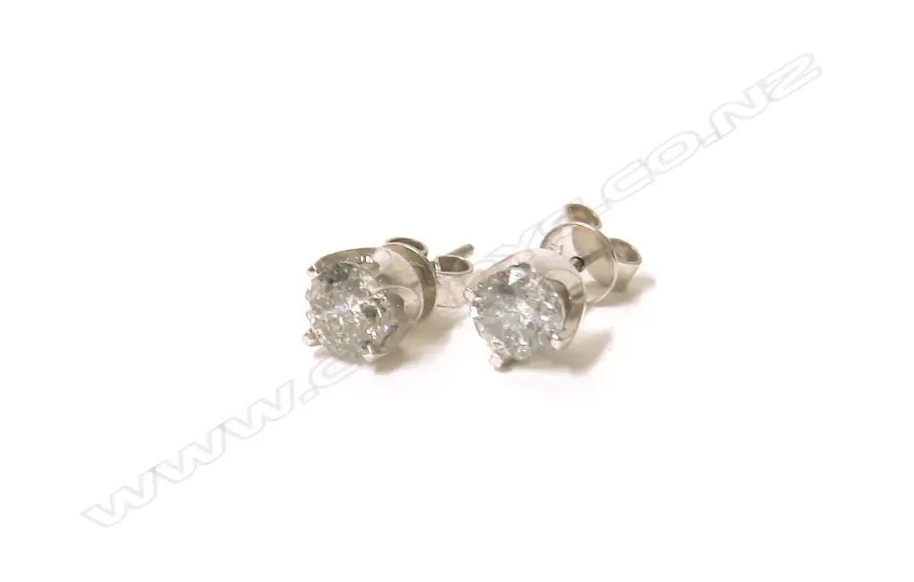 A pair of 18ct. white gold and solitaire diamond stud earrings Image 1++