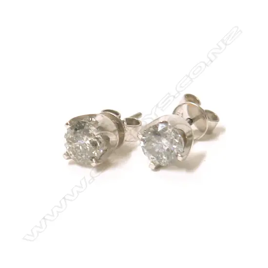 A pair of 18ct. white gold and solitaire diamond stud earrings