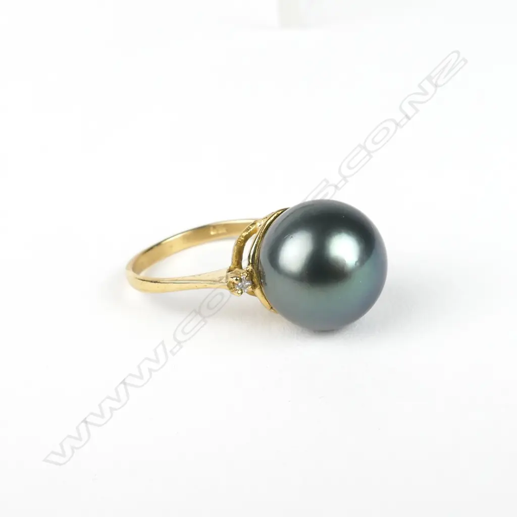 An 18ct. gold diamond and black pearl ring Image 1++