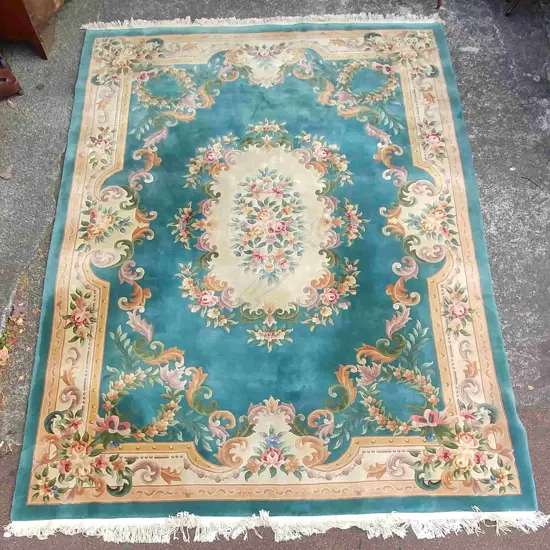 A large Chinese handmade wool carpet decorated in the French manner with leaves