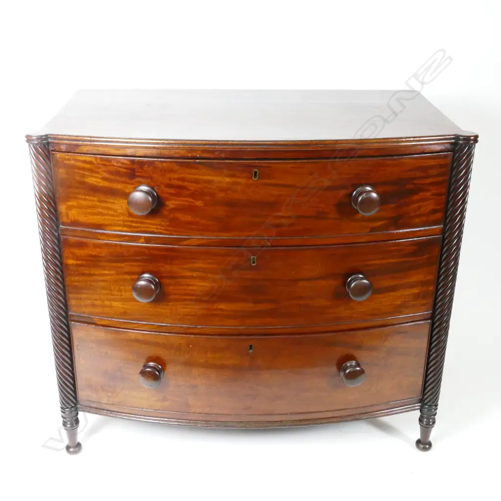 A mahogany bowfront chest of three drawers Image 1++
