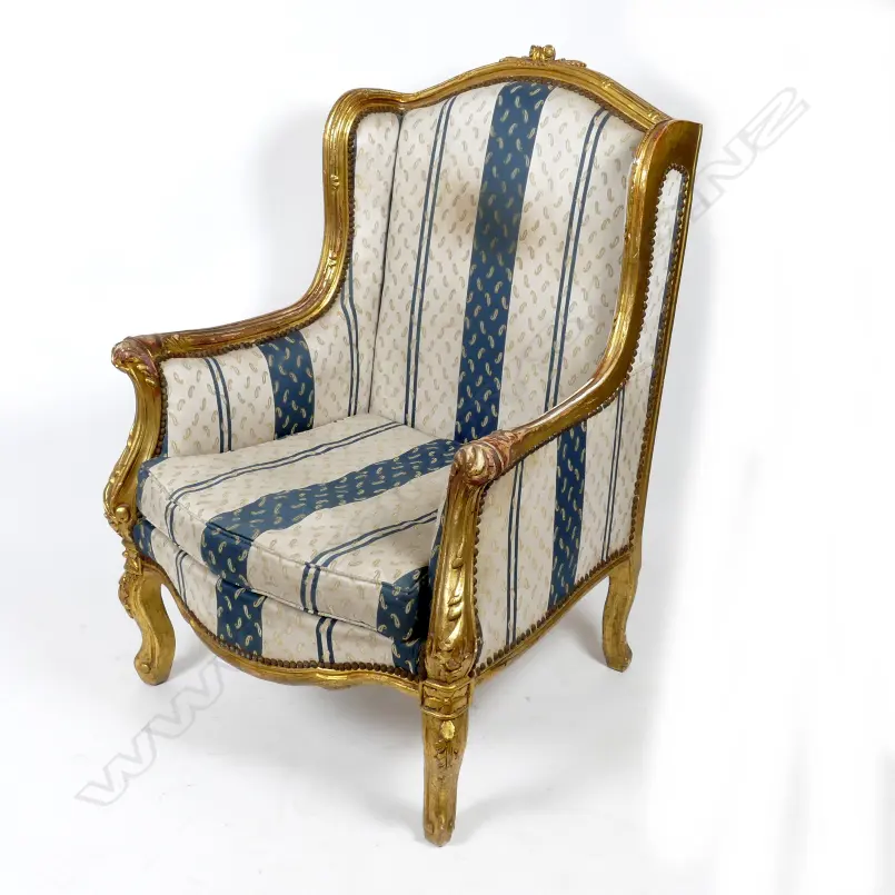 A pair of large gilt wing back armchairs of French style with leaf Image 1++