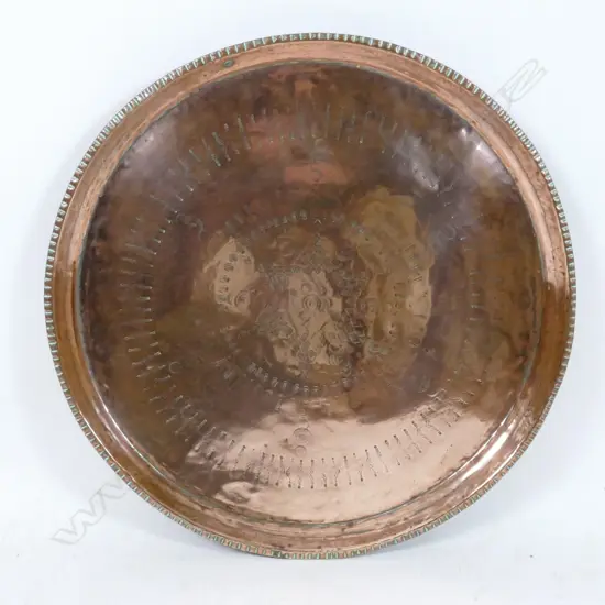 A large old circular copper tray