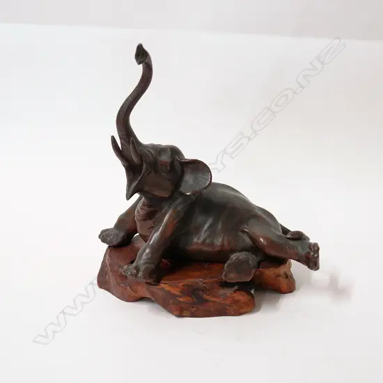 A Japanese Meiji bronzed spelter recumbent elephant
