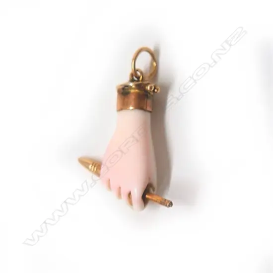 A 19thC carved pale pink coral and gold clasped hand pendant