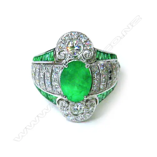 An impressive modern 16-18ct. white gold emerald and diamond cluster ring